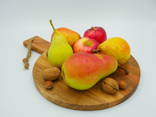 Wooden plate filled with autumn fruits and nuts