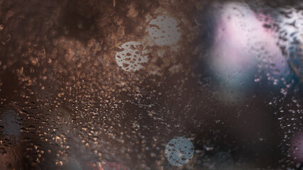 Fototapeta na wymiar Blurred background with raindrops and lights.