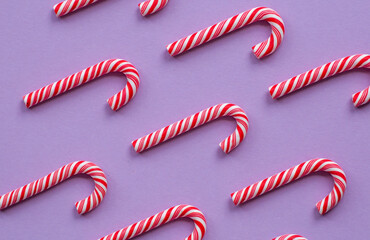 Christmas candy cane close-up on a purple background. The concept of Christmas and New year 2023 for a candy store.