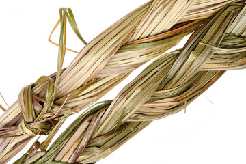 Sweet grass braid (Hierochloe odorata), also called vanilla grass, used by indigenous peoples in North America as herbal medicine and incense (smudges) to attract good spirits. Close up, top view. - obrazy, fototapety, plakaty