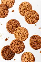 Flying oatmeal cookies with crumbs isolated on white background. Levitation food concept. Healthy eating