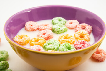 Uma vasilha cheia de leite com cereais coloridos.