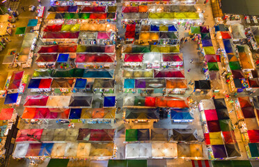 Fototapeta na wymiar Aerial top view of Night Market people walking street, Colorful tents in the train of Ratchada at Bangkok city, Thailand. Rerail shops