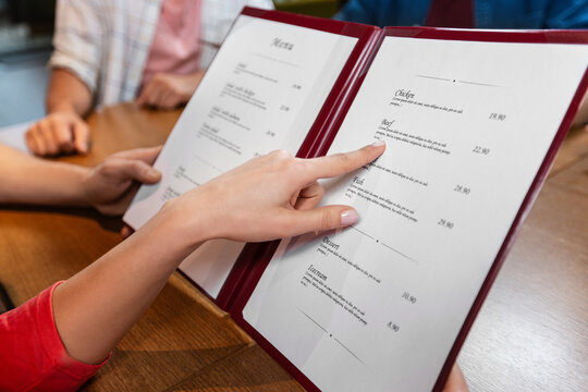 leisure and people concept - close up of couple with menu at restaurant