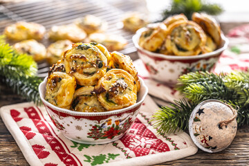 Christmas savory pastries, mini pizza cakes in a typical Christmas dish and festive decorations - obrazy, fototapety, plakaty