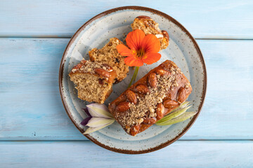 Caramel and almond cake on blue wooden, top view.