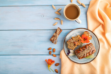Caramel and almond cake on blue wooden, top view, copy space.