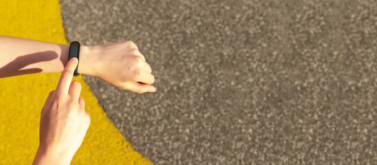 Hand with fitness bracelet, using sport wristband. Ad banner with background, copy space for text