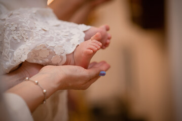 small children's legs close-up in mom's hands