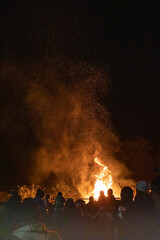 Fototapeta na wymiar Crowd Stood In Front Of A Roaring Bonfire