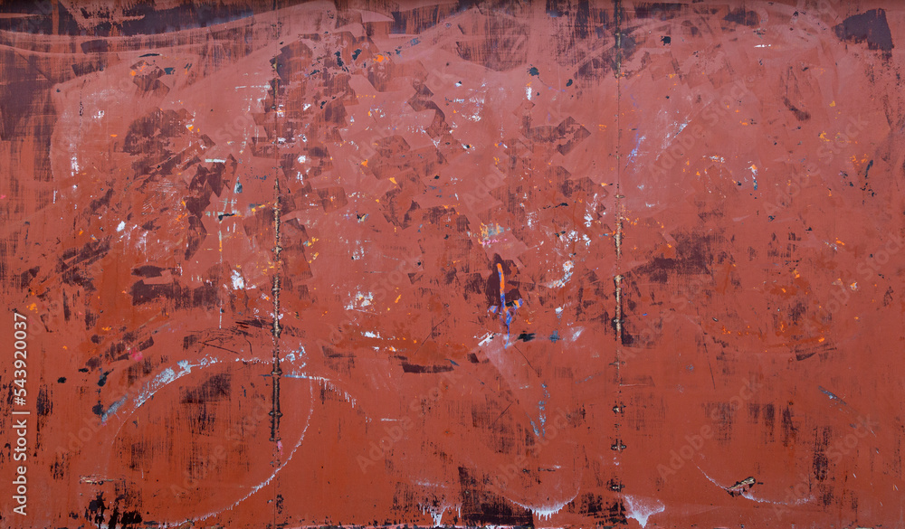 Poster front view of a messy, dirty and weathered plywood wall painted in red with stains from graffiti rem
