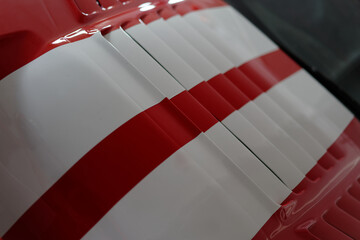 Bonnet of a powerful american red race car. Red with white stripes. Vintage car wallpaper. Classic...
