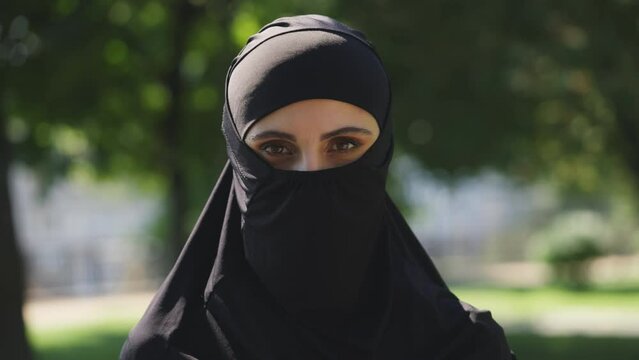 Portrait of woman in ultra-orthodox muslim dress looking at camera, traditions
