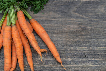 Organic carrots on wooden table.