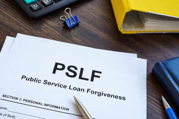 Papers foe Public Service Loan Forgiveness PSLF on the wooden surface. - obrazy, fototapety, plakaty