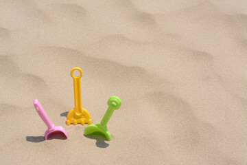 Set of colorful beach toys on sand, space for text