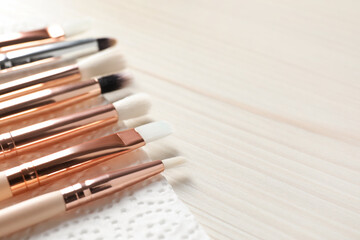 Set of different makeup brushes drying after cleaning on white wooden table, closeup. Space for text