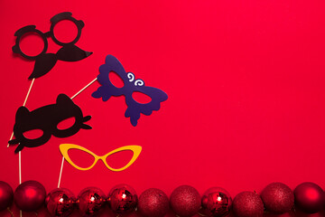 A red color background with a carnival masks on a wood stick. Holiday banner. A props for...