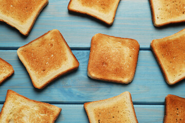 Slices of tasty toasted bread on turquoise wooden table, flat lay