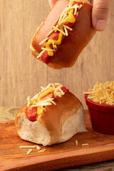 Holding delicious mini hot dog. Selective focus.