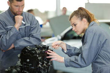female mechanic using spanner on engine