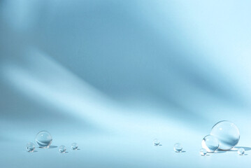 Blue background with transparent glass balls. Minimal concept and soft sunlight.