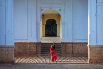 Yogini dancing and practicing yoga near a palace in Mysore, India. Mindful yoga practice....