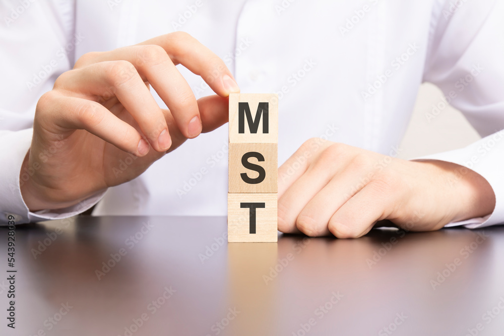 Aufkleber mst, marketing solutions and technologies text on cube blocks in businessman hands, man in white shi