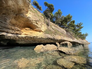 Scenic cave grotto and coastal cliffs in the sea.
