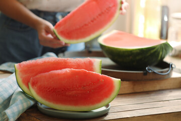 Woman taking fresh fruit indoors, focus on slices of juicy watermelon © New Africa