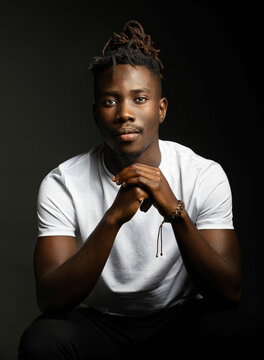 portrait of a black man with white shirt looking at camera