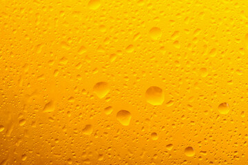 Glass of tasty cold beer with condensation drops as background, closeup