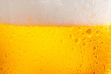 Glass of tasty cold beer with foam and condensation drops as background, closeup - obrazy, fototapety, plakaty