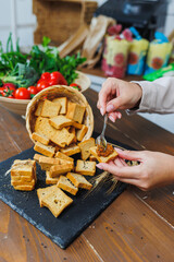 Slices of toasted bread and pate in female hands. Fresh croutons made of whole grain flour