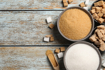 Flat lay composition with different types of sugar on rustic table, space for text