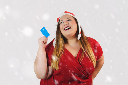 plus size woman smiling with a card at christmas.
