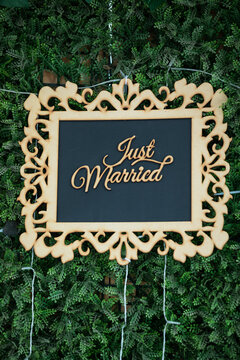Just married frame sign with green foliage in background