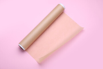 Roll of baking paper on pink background, top view