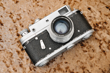 Old vintage film camera on the table. Retro photo camera with silver-black body.