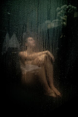 Frau sitzt nackt in der Dusche