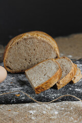 Slices of whole grain rye fresh bread on a dark background close up. Fresh home-baked sourdough bread
