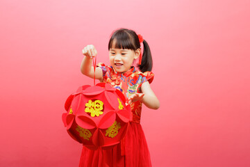 Obraz na płótnie Canvas Chinese girl with traditional dressing up hold a Fu means 'lucky' greeting lantern against pink background