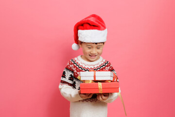 Merry Christmas! Young girl celebrating Christmas against pink background