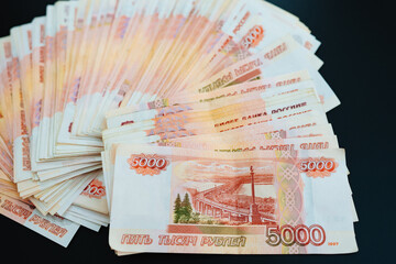 a fan of banknotes of 5000 rubles on a black background. 