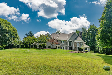 Fototapeta na wymiar Luxury custom built hillside home with beautifully designed front yard and lawn in a residential area in Virginia.