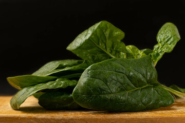 Fresh spinach leaves on black background.