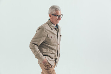 old casual man walking with hands in pockets