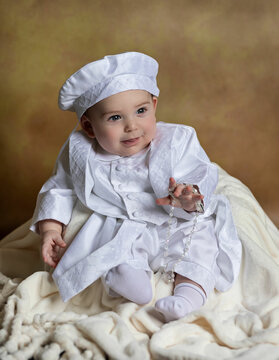 Smiling baby dressed in white clothes and brown fine art backdrop