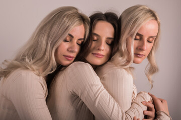 Three female friends, sisters, hugging each other.