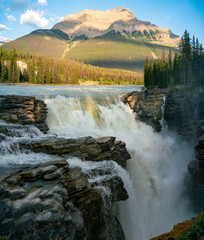 Powerful waterfalls of Athabasca Falls at sunset in summer. Jasper National Park, Alberta, Canada.